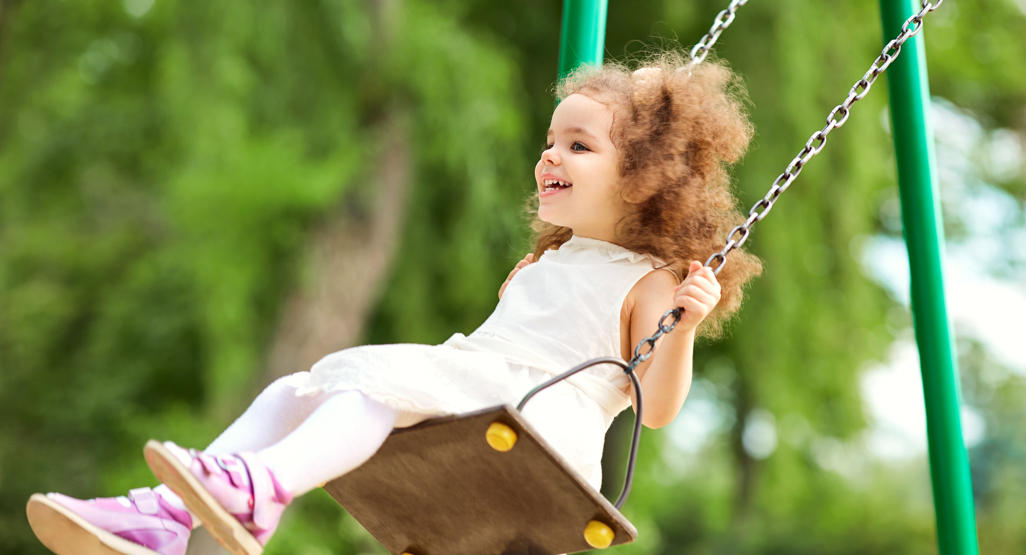 girl on a swing looking cheerful