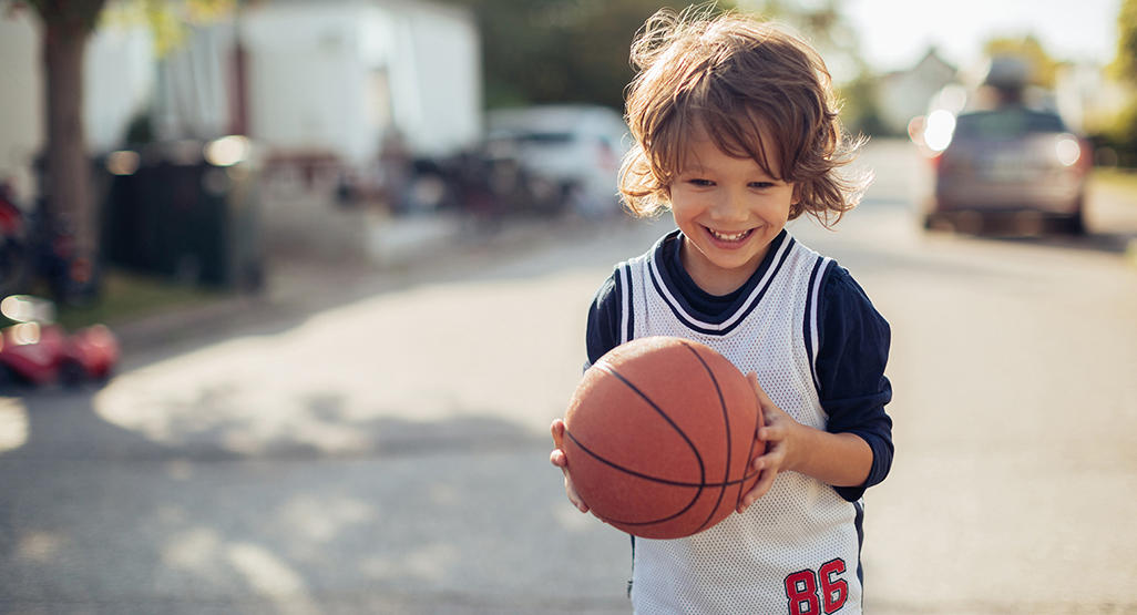 boy holding a basketball outside